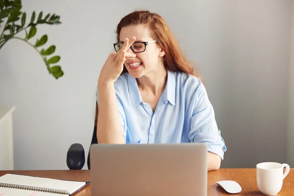 Portrait of a disgusted girl pinching her nose. Young girl holding her nose smelling something stinking. Businesswoman wearing glasses and blue shirt looking with disgust. Bad smell situation, human f