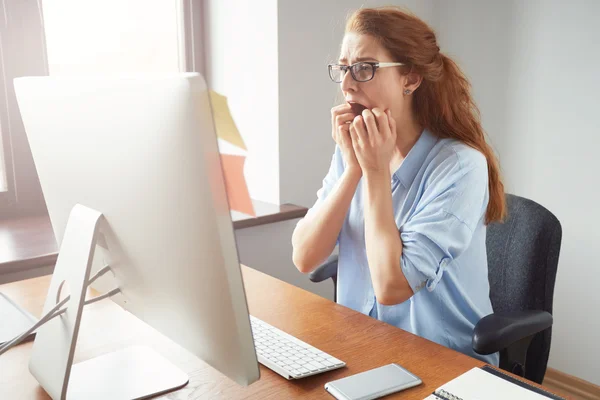 Shocked businesswoman sitting in front of computer