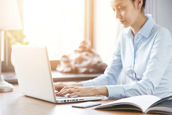 Female entrepreneur typing on laptop