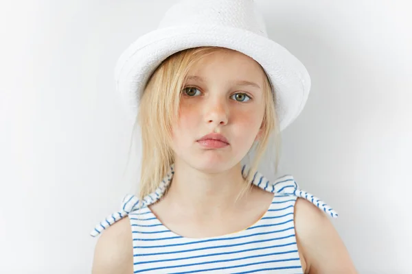 Image of beautiful 5-year female kid wearing stylish clothes looking with serious expression at the camera. Lifestyle and people concept. Adorable Caucasian little girl with green eyes and blonde hair