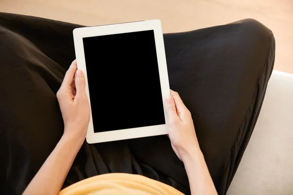 Cropped shot of female office worker holding digital tablet with blank copy space screen for your text or advertsing content. Housewife in casual clothes using electronic device for online shopping