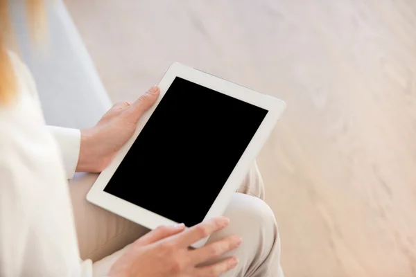 Close up of female hands holding digital tablet with copy space screen for your advertisement. Redhead student girl doing homework using electronic gadget with high-speed Internet. Selective focus