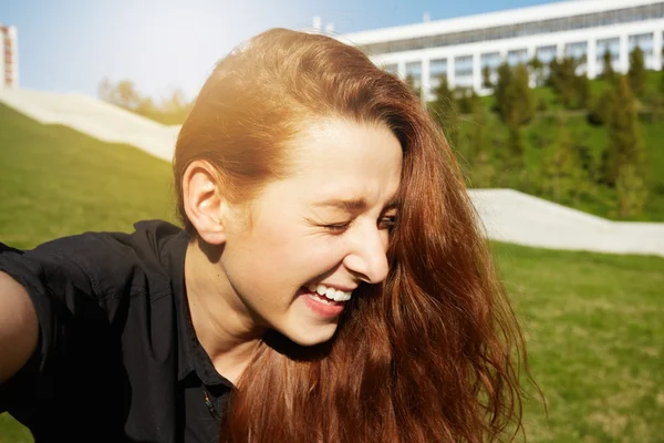 Redhead woman laughing with closed eyes
