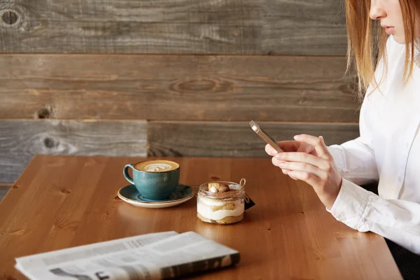 People, leisure and technology concept: young woman photographing sweet dessert on mobile phone, hipster girl taking photo of her morning breakfast using cell phone camera while sitting in cafe