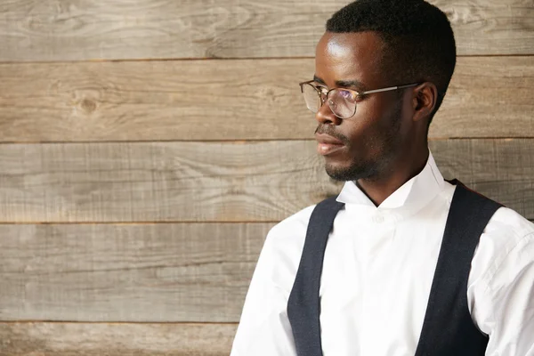 Career and success concept. Portrait of young successful African American businessman or CEO in formal wear and spectacles, looking away with confident expression, thinking of his business plans