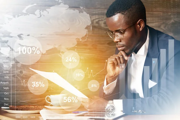 Film effect. Worldwide connection interface. African financier dressed in elegant suit sitting at a cafe, holding papers, reading documents with concentrated attentive expression, touching his chin