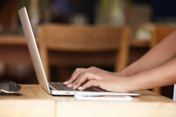 Cropped shot of hands of dark-skinned woman-writer hand typing on keyboard of laptop computer, finishing a chapter of her new bestseller, sitting against home interior background. Selective focus