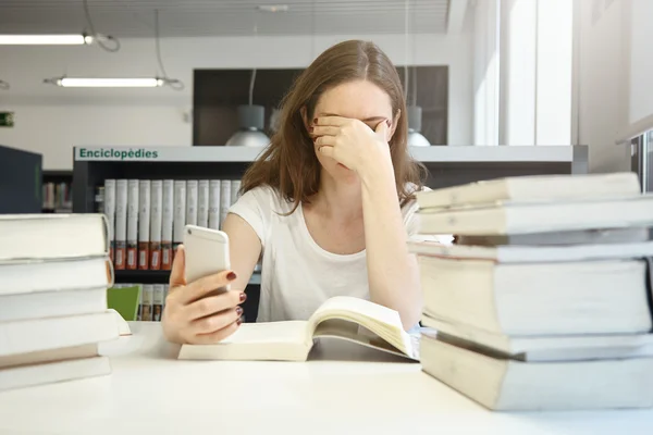 Female student at library with smart phone