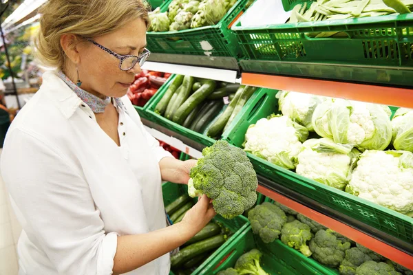 Middle-aged Caucasian woman choosing vegetables