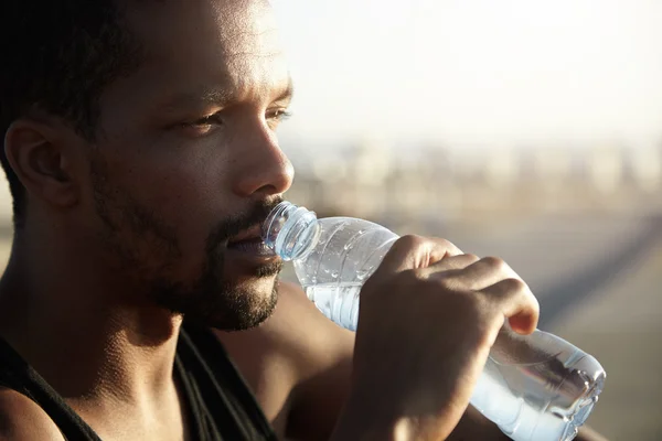 Sportsman drinking water from bottle