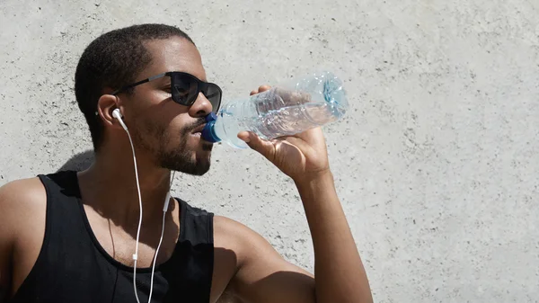 Athlete drinking water from plastic bottle
