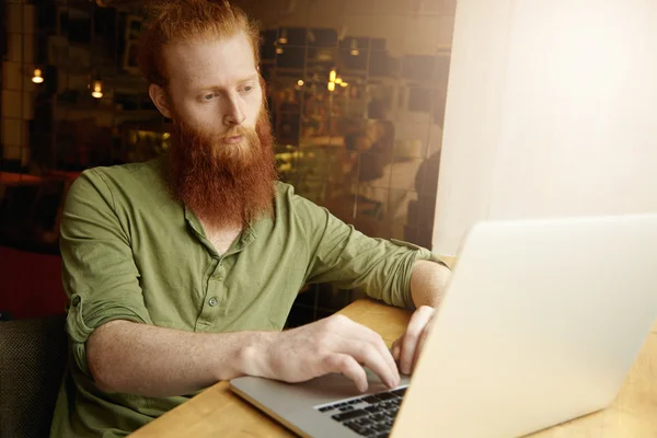 Stylish guy playing  on notebook