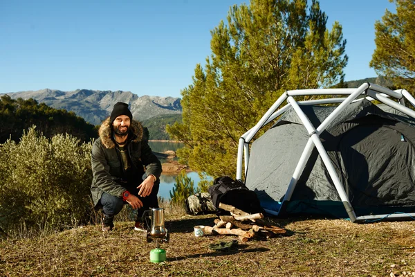 Hiking people. Adventure man camping waits to make coffee on a g