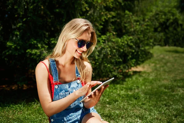 Portrait of happy young blonde woman college student use tablet