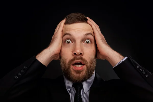 Closeup portrait of handsome bearded businessman looking shocked, surprised in disbelief, with hands on face looking at you camera, isolated on background. Positive human emotions, facial expressions.