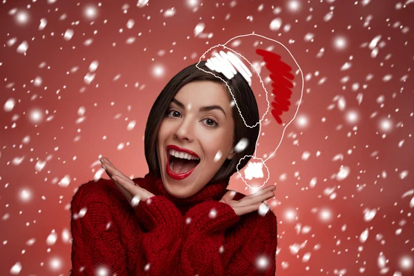 Christmas woman. Beauty model in santa hat and red sweater standing around snow isolated. Funny laughing surprised woman portrait with open mouth. True Emotions. Red lips. Beautiful holiday makeup.