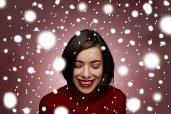Winter beauty happy smiling woman. Christmas or new year girl concept. Sweet girl in the red sweater standing around snow isolated.