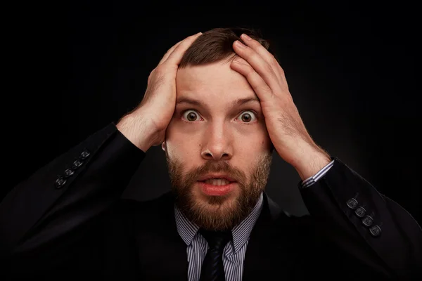 Closeup portrait of handsome bearded businessman looking shocked, surprised in disbelief, with hands on face looking at you camera, isolated on background. Positive human emotions, facial expressions.