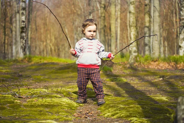 The child with the sticks to walk.