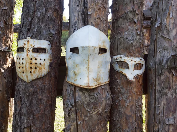 Medieval iron mask hanging on the fence.