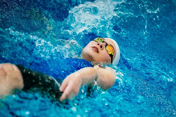 Young female athlete swimming backstroke