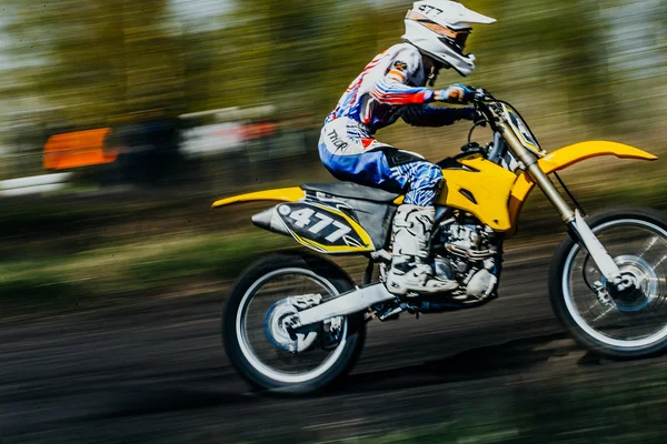 Closeup of a rider on a motorcycle rides on race track. Motion blur