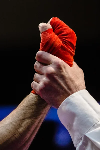 Referee raises  hand of  boxer is winner