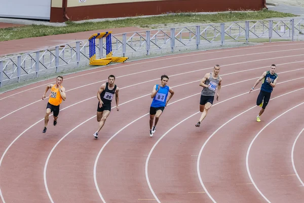 Running men athletes at sprint distance of 200 meters