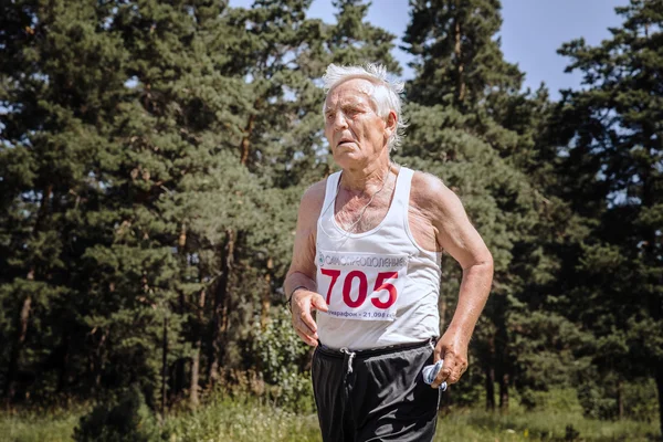 Old man runs across road in forest
