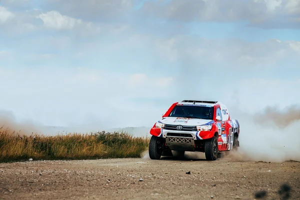 Rally Toyota car rides on dusty road