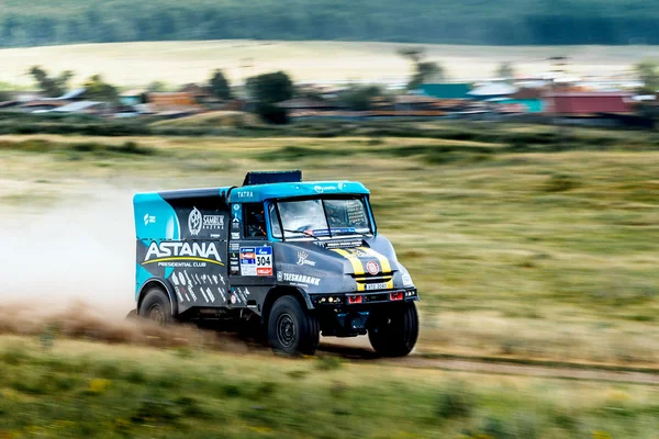 Rally truck rides at high speed on a dusty road