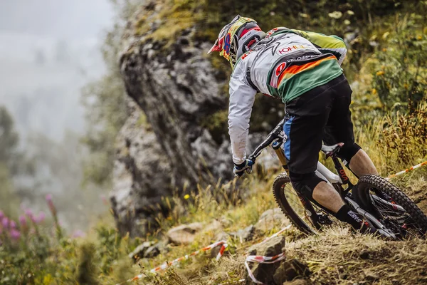 Closeup of a young rider athlete on bike rides on a mountain trail