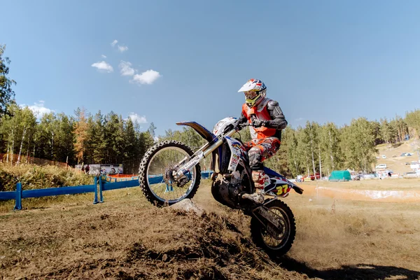 Racer on a motorcycle rides uphill on rear wheel