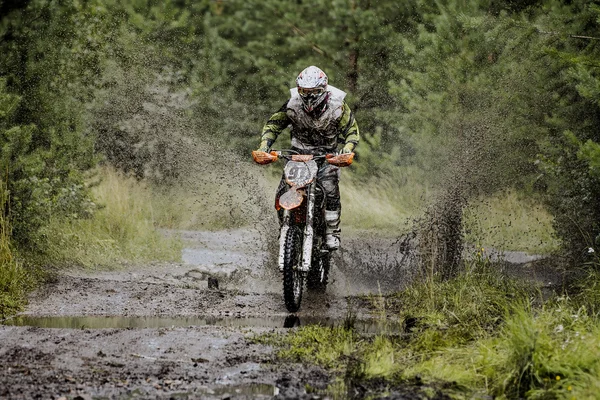 Extreme racer on a motorcycle rides puddle