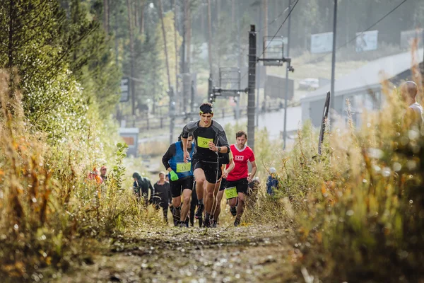 Runner leader runs ahead group of athletes marathoners