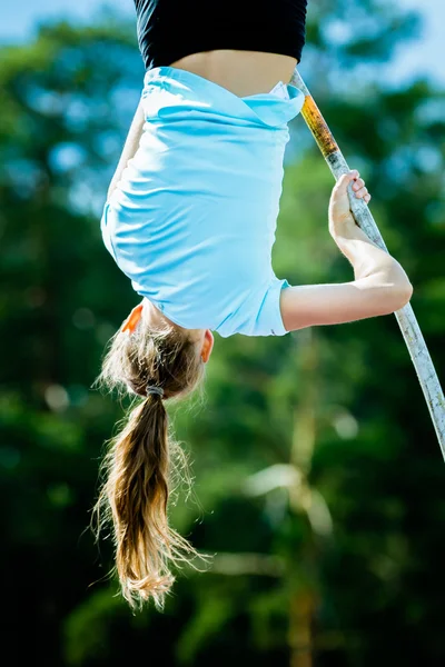 A female athlete competing in the pole vault