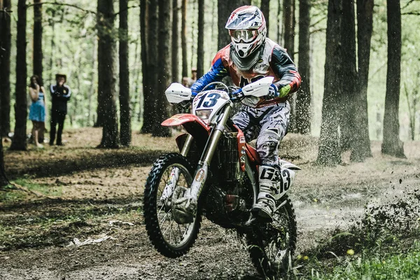 Motocross driver under the spray of mud
