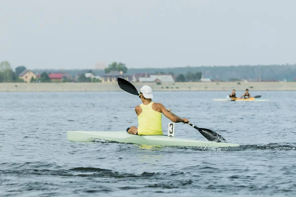 Boy in sport kayak paddles on water
