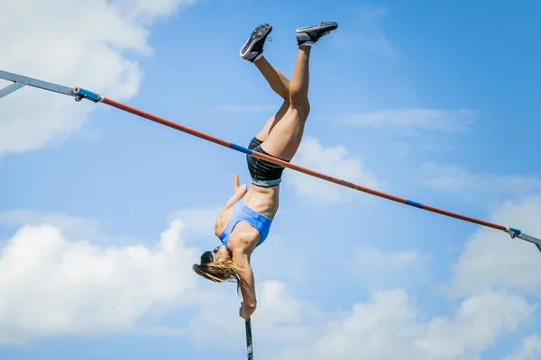 Girl athletes pole vault seems to reach the sky