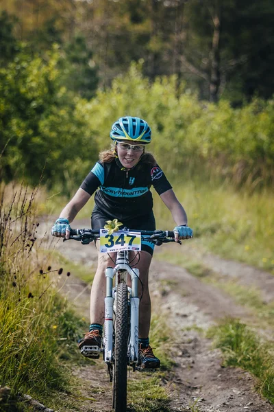 Girl racer on bike rides on the trail