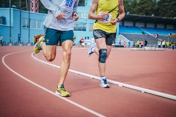 Two athletes running on the track stadium
