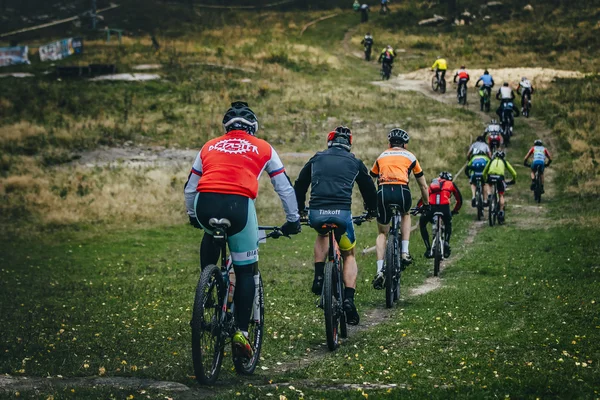 Long line of riders on bike going uphill