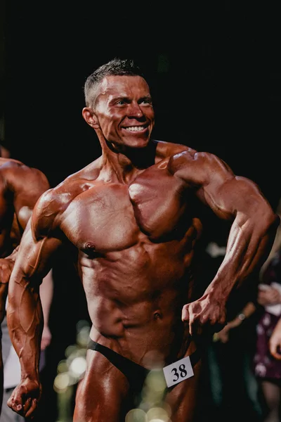 Smiling athletes bodybuilders are straining your chest and press