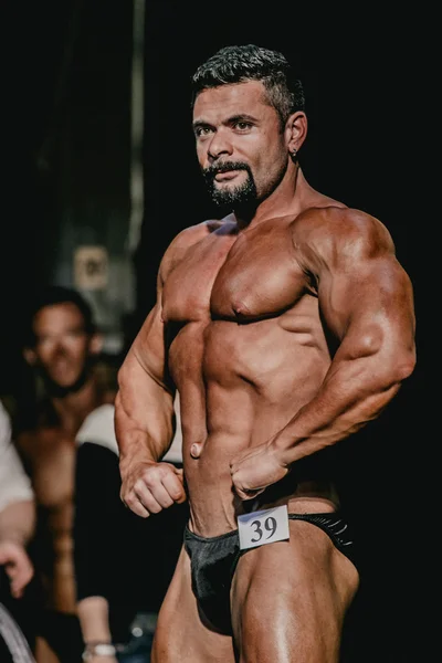 Greek athlete bodybuilder straining abs and arms