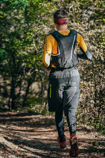 Athlete man running mountain marathon along a forest trail