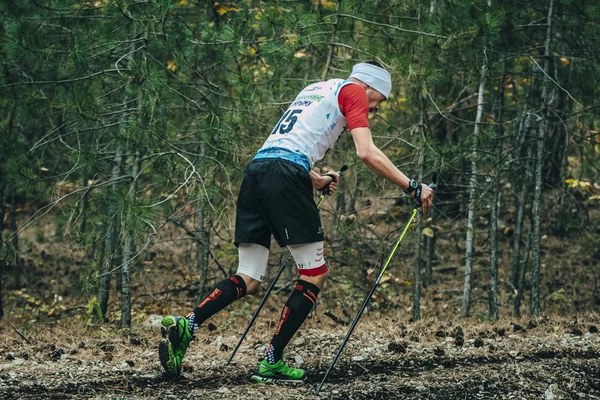 Athlete running with nordic walking poles in compression socks