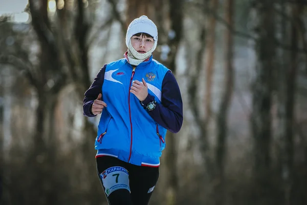 Beautiful young woman running in winter forest