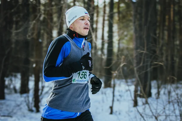 Closeup of young man running in winter woods