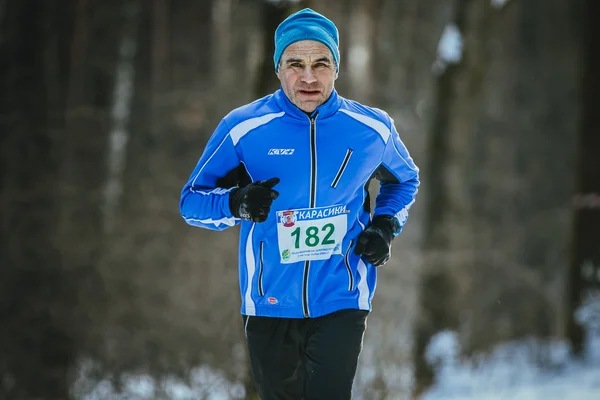 Old men athlete runs at winter Park