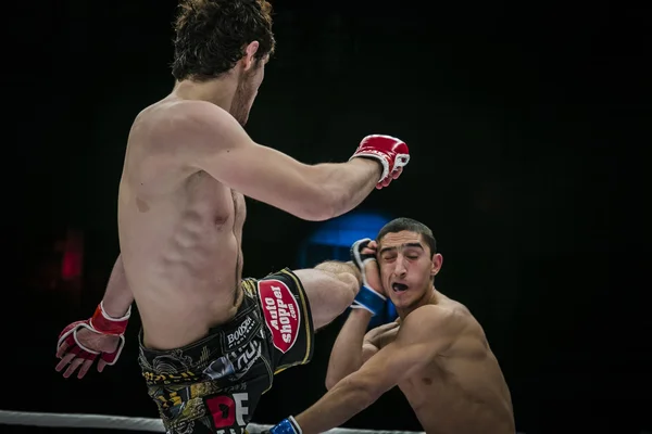 Athlete mixed martial arts fighter strikes his foot on head of his opponent